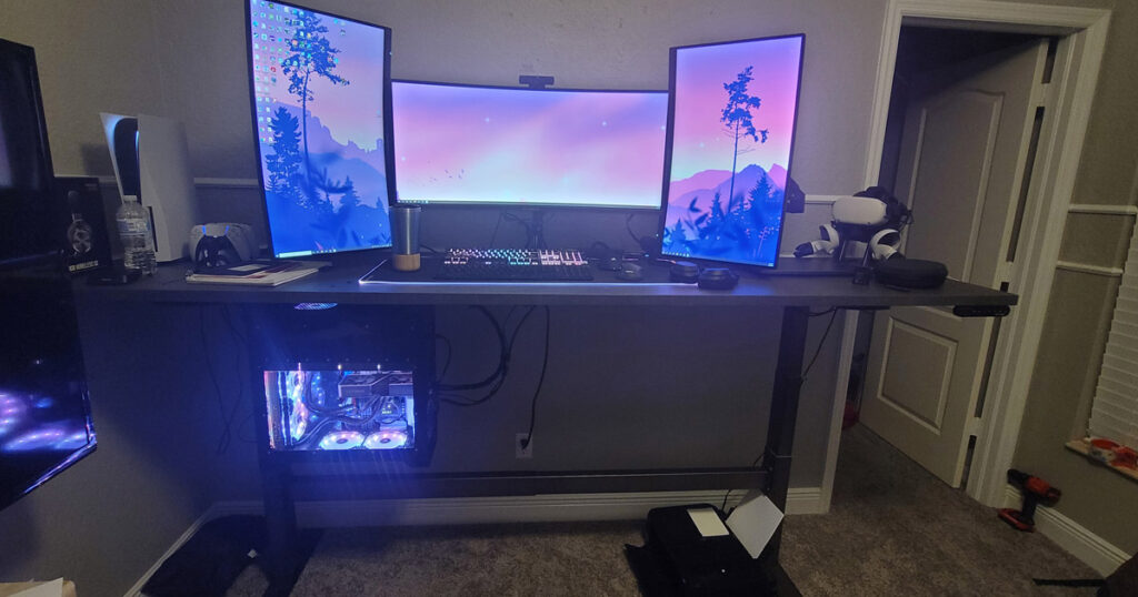 Uplift V3 en un setup home office con doble monitor, fondo limpio. Alt: "Escritorio de pie Uplift V2 en home office con setup de doble monitor